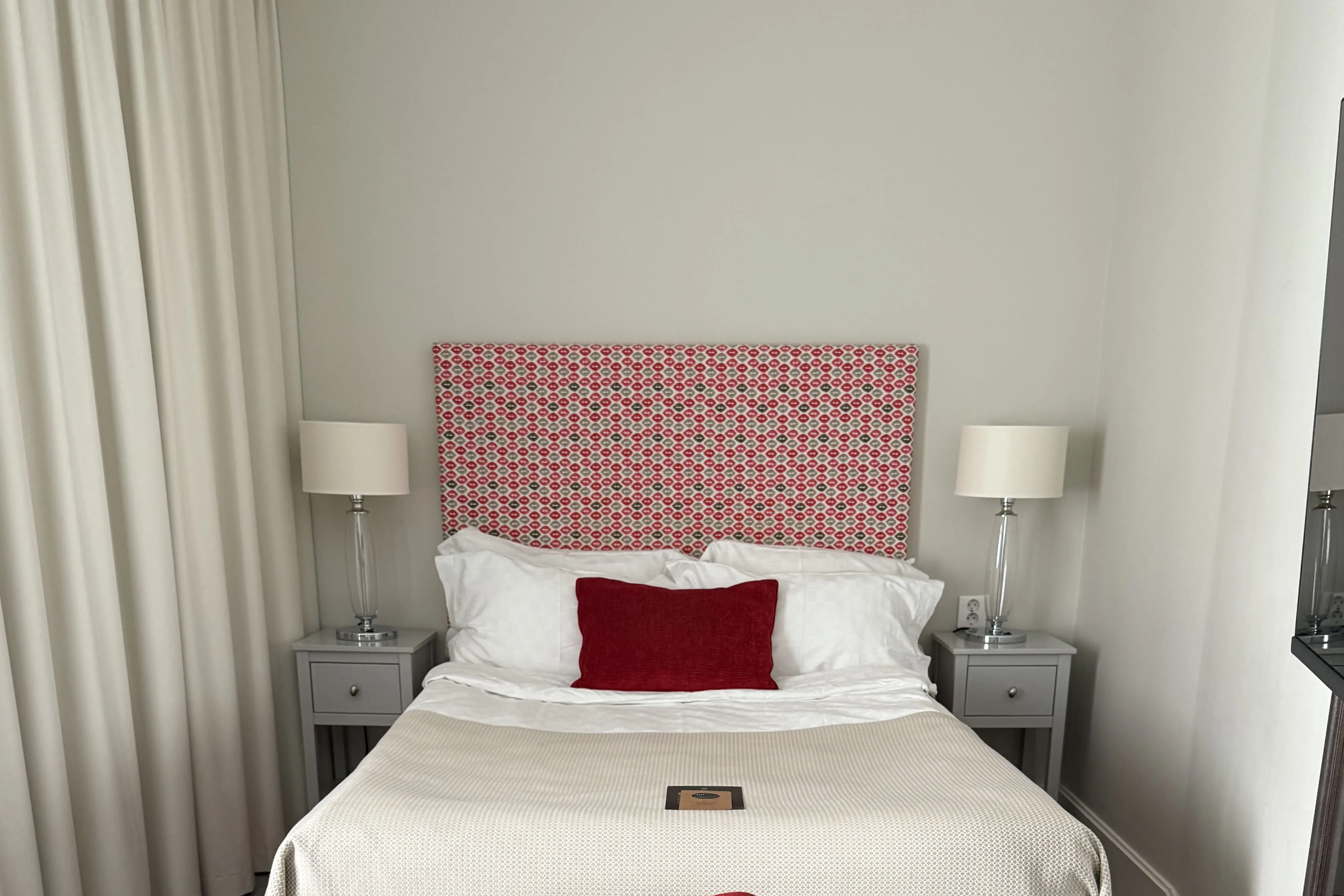 Hotel room with double bed, red headboard and desk