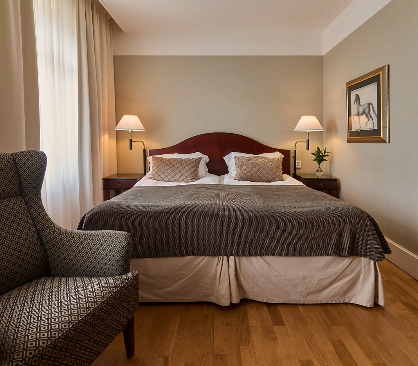 Hotel room with desk, armchair and curtains