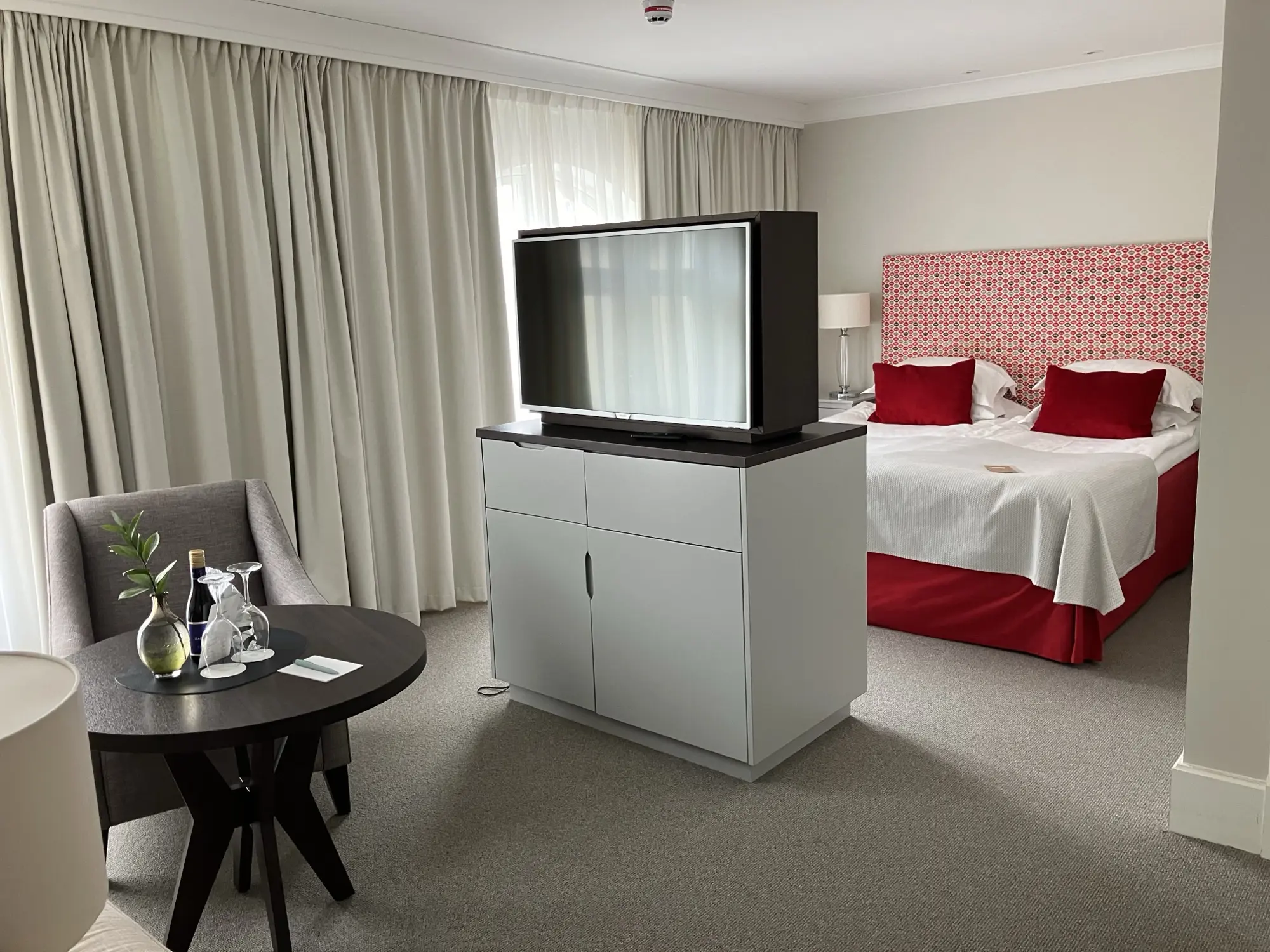 Suite with mirror, seating area and green tiled stove