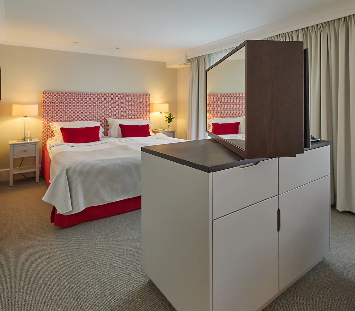 Suite with mirrors, seating area and green tiled stove