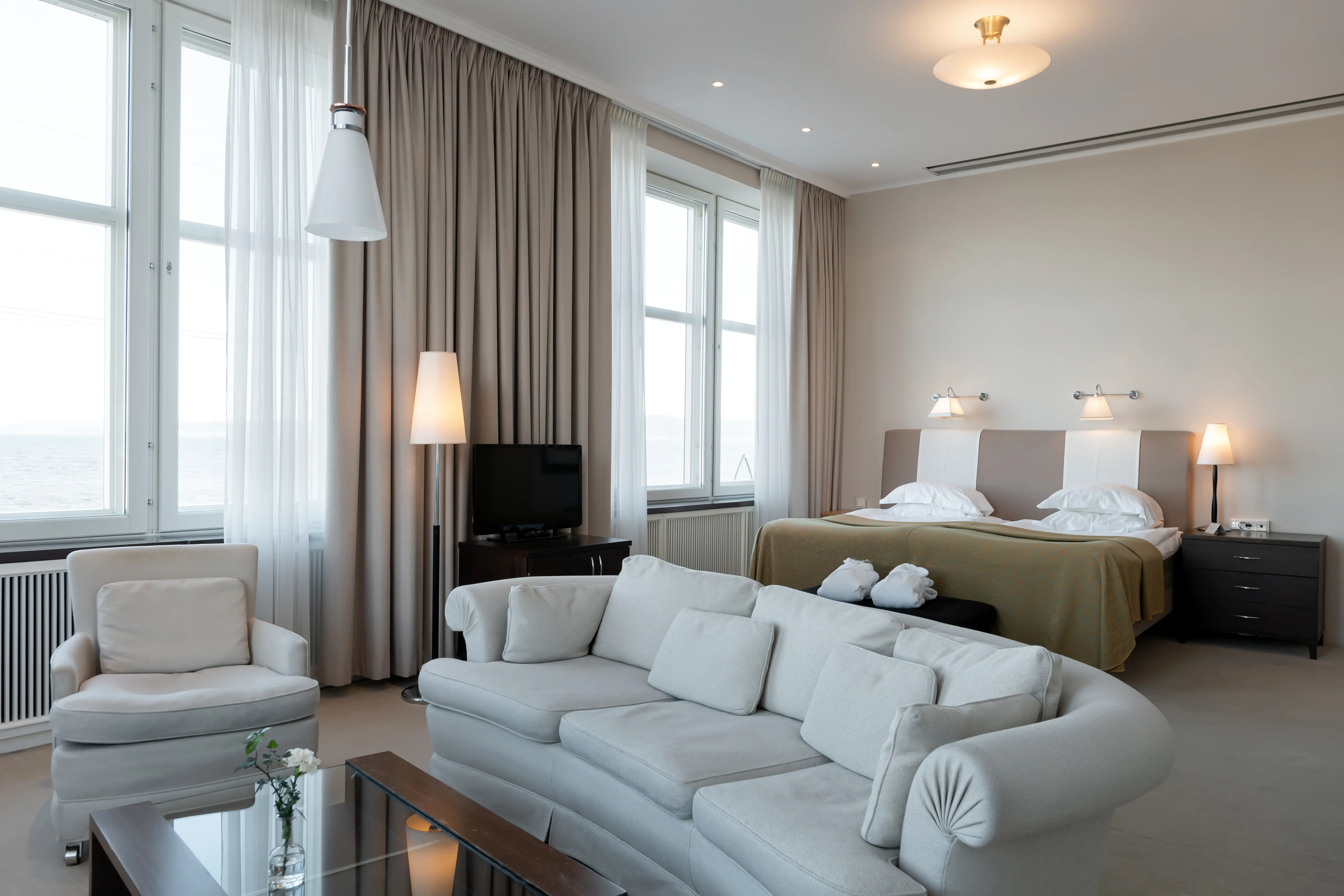 Suite with bed, sitting area and large windows