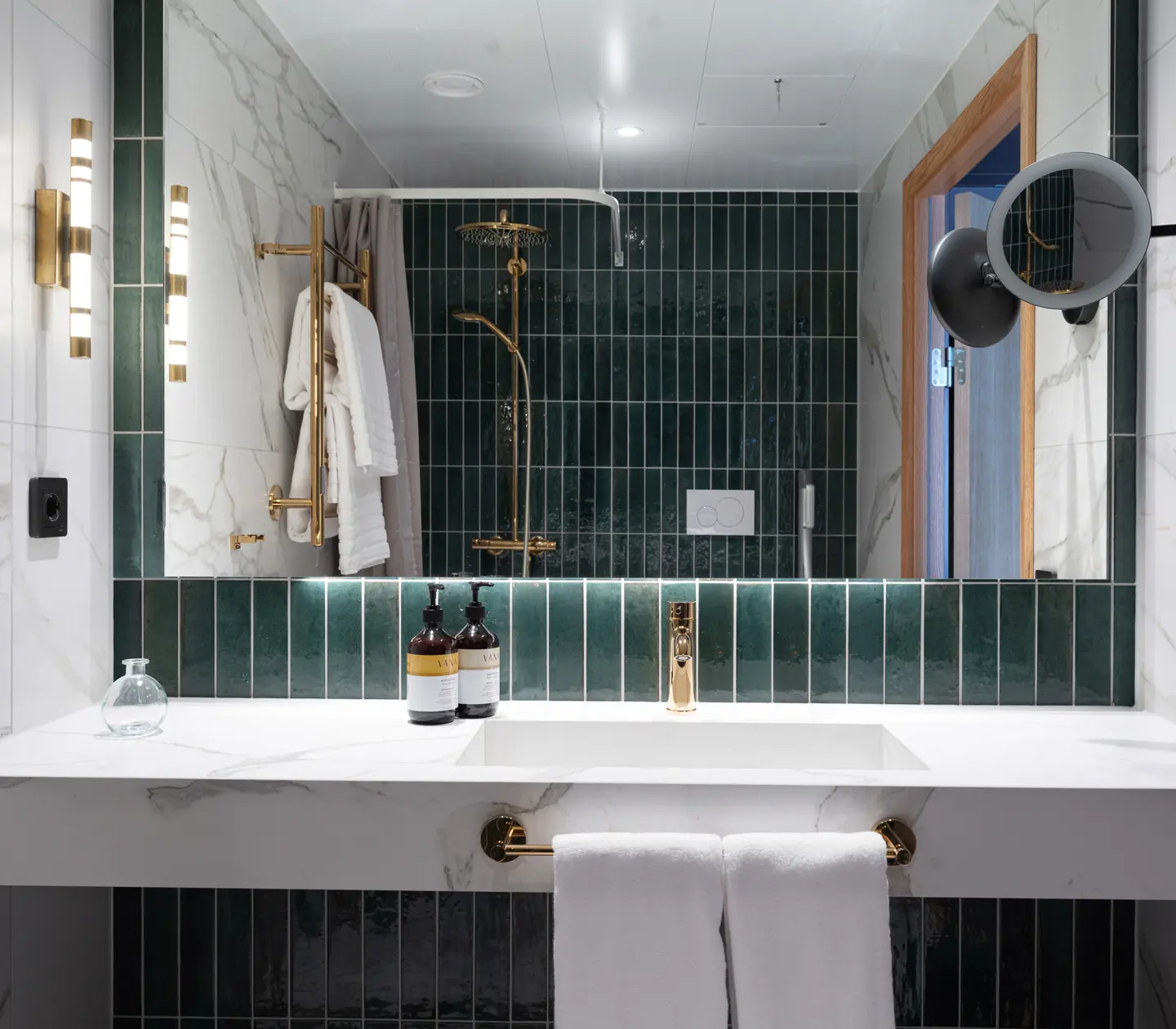 Green bathroom with a wide mirror and a marble sink