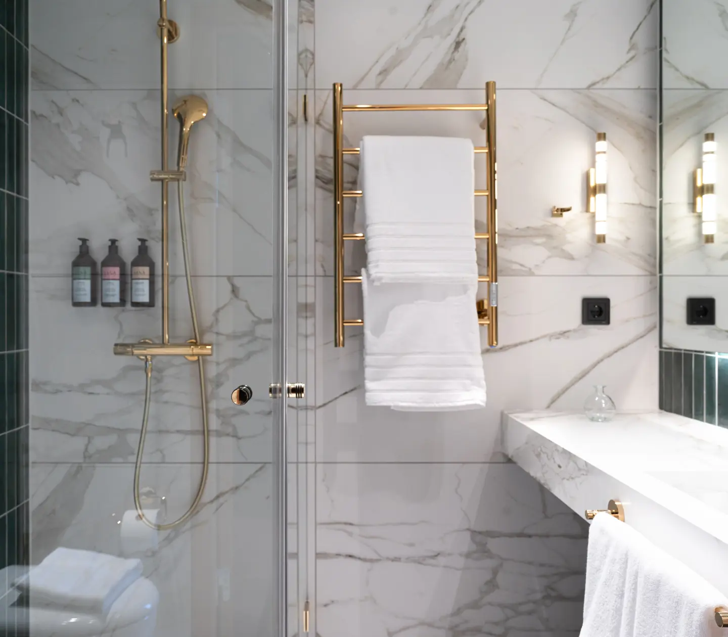 Overall view of a standard bathroom with green tiles and marble.