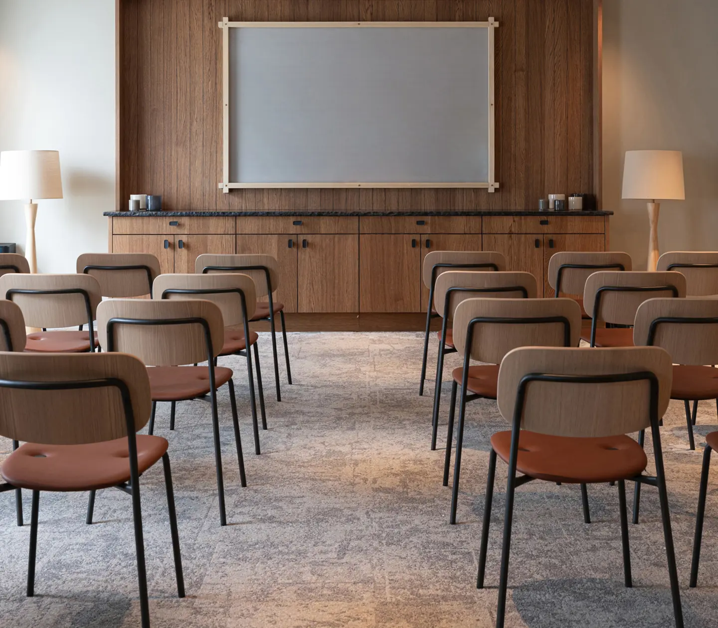 Cozy conference lobby in the evening with modern decor, elegant furniture, and ambient lighting, offering a view of the nature-filled surroundings through large windows