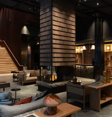 Cozy hotel lobby with plenty of seating and a fireplace in the middle.
