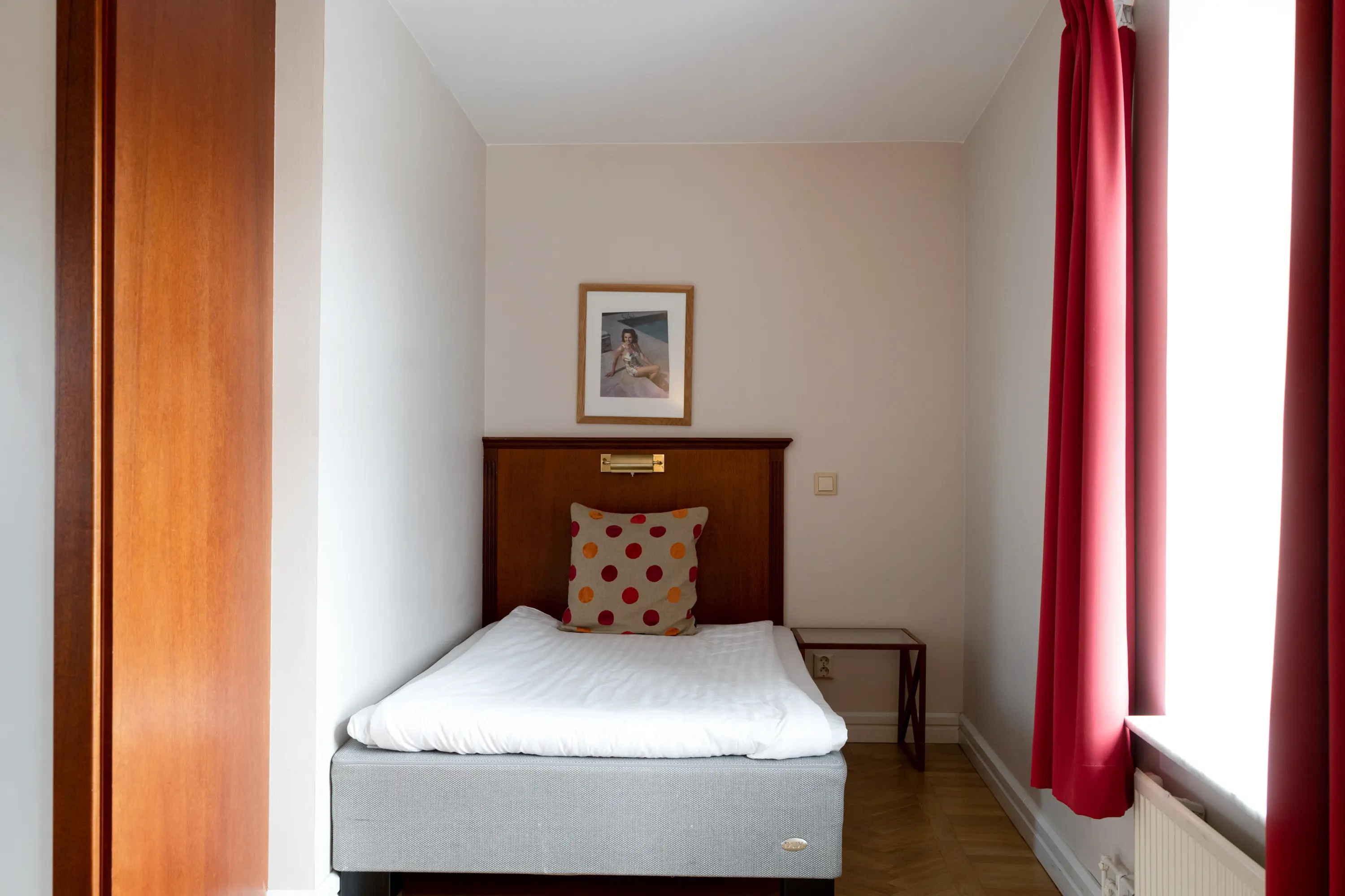 Hotel room with bed, wooden headboard and window