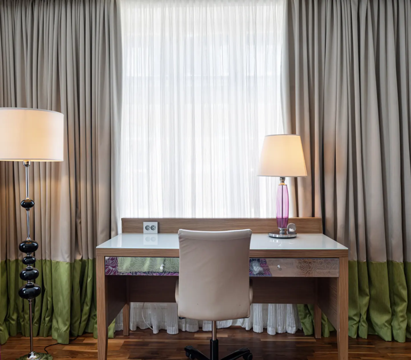 Hotel room with armchair, desk and window