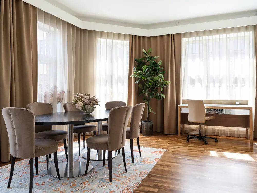 Suite with dining table, floor lamp and large windows