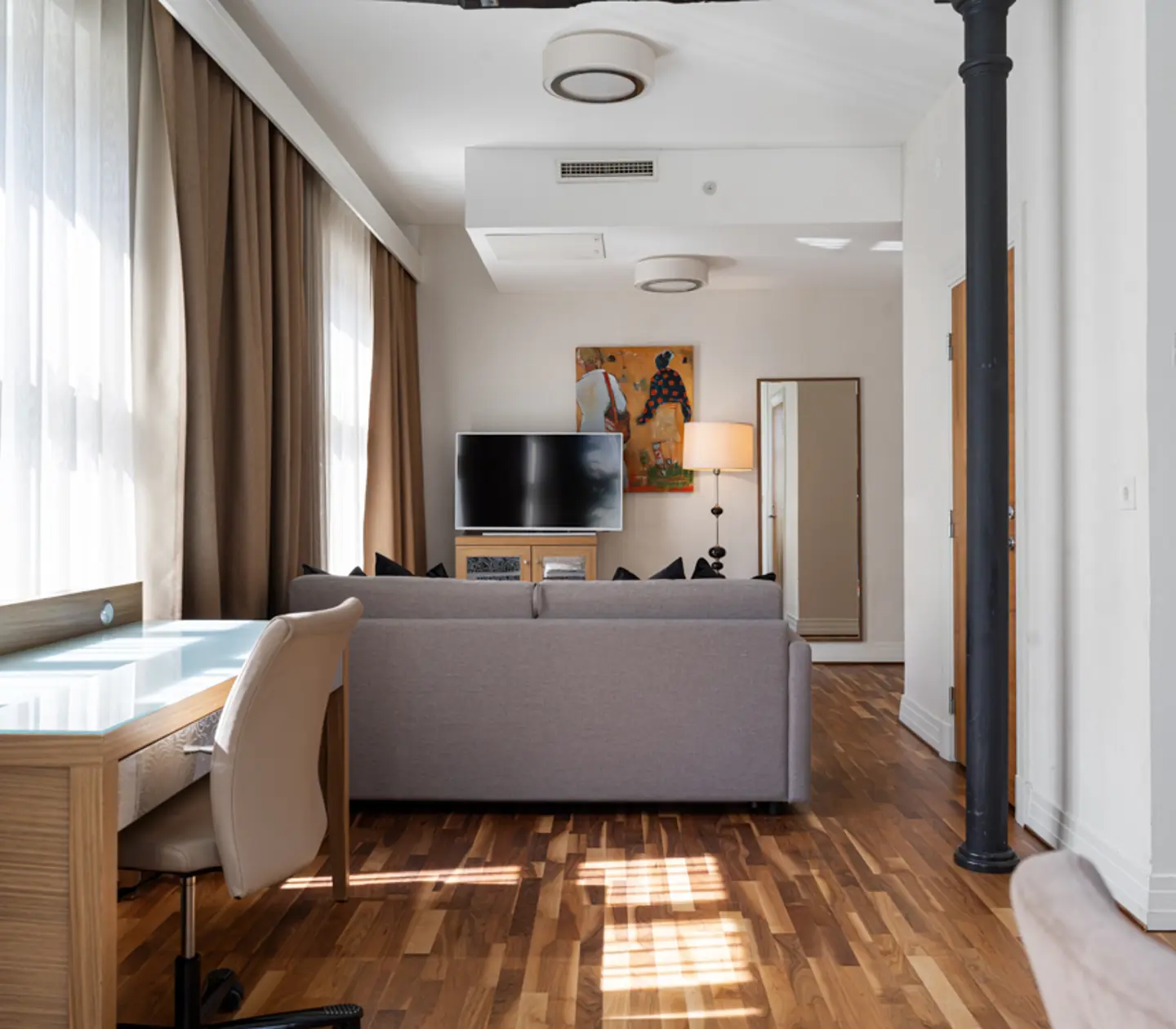 Suite with dining table, TV and large windows