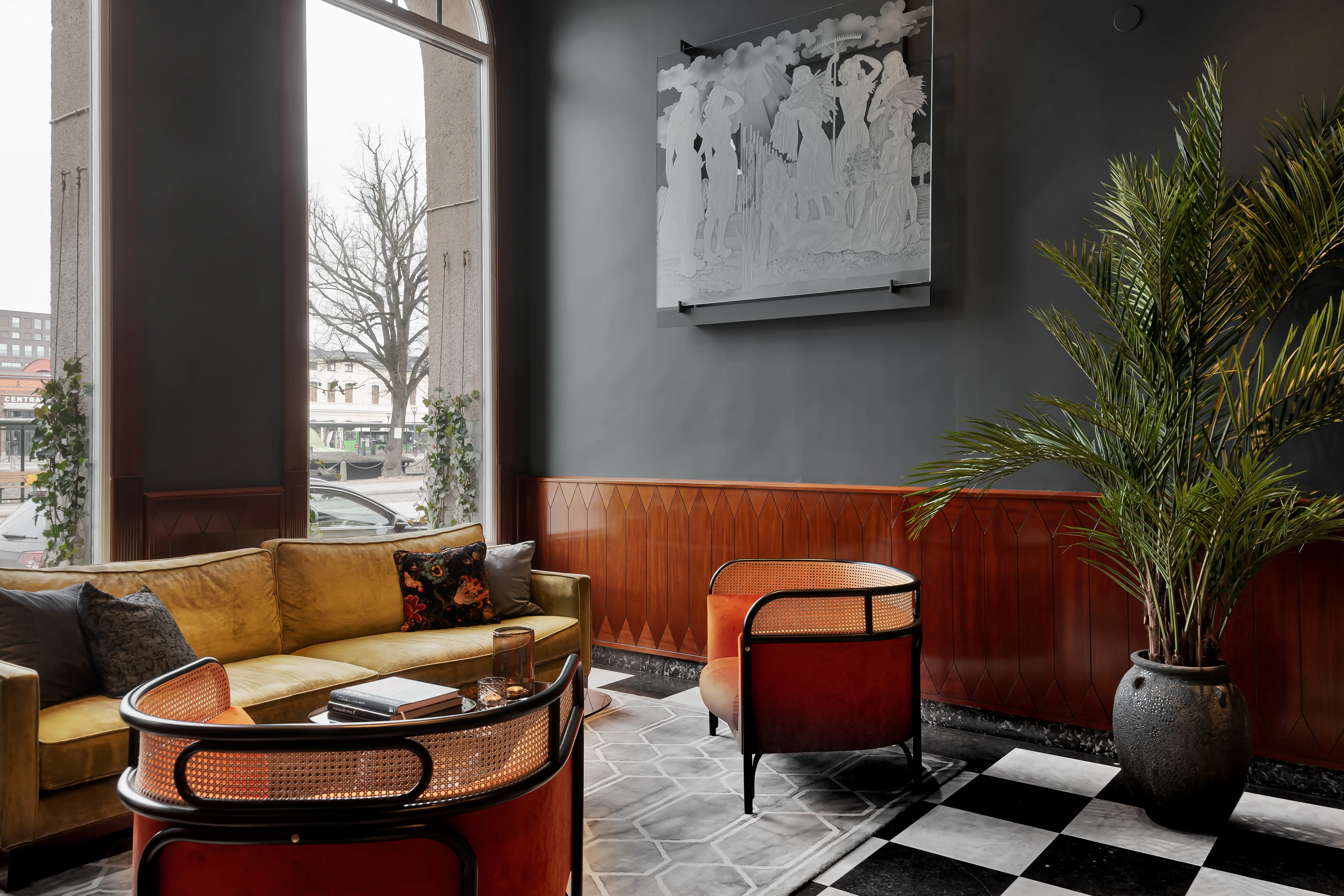 Hotel lobby with lounge group, potted plants and paintings