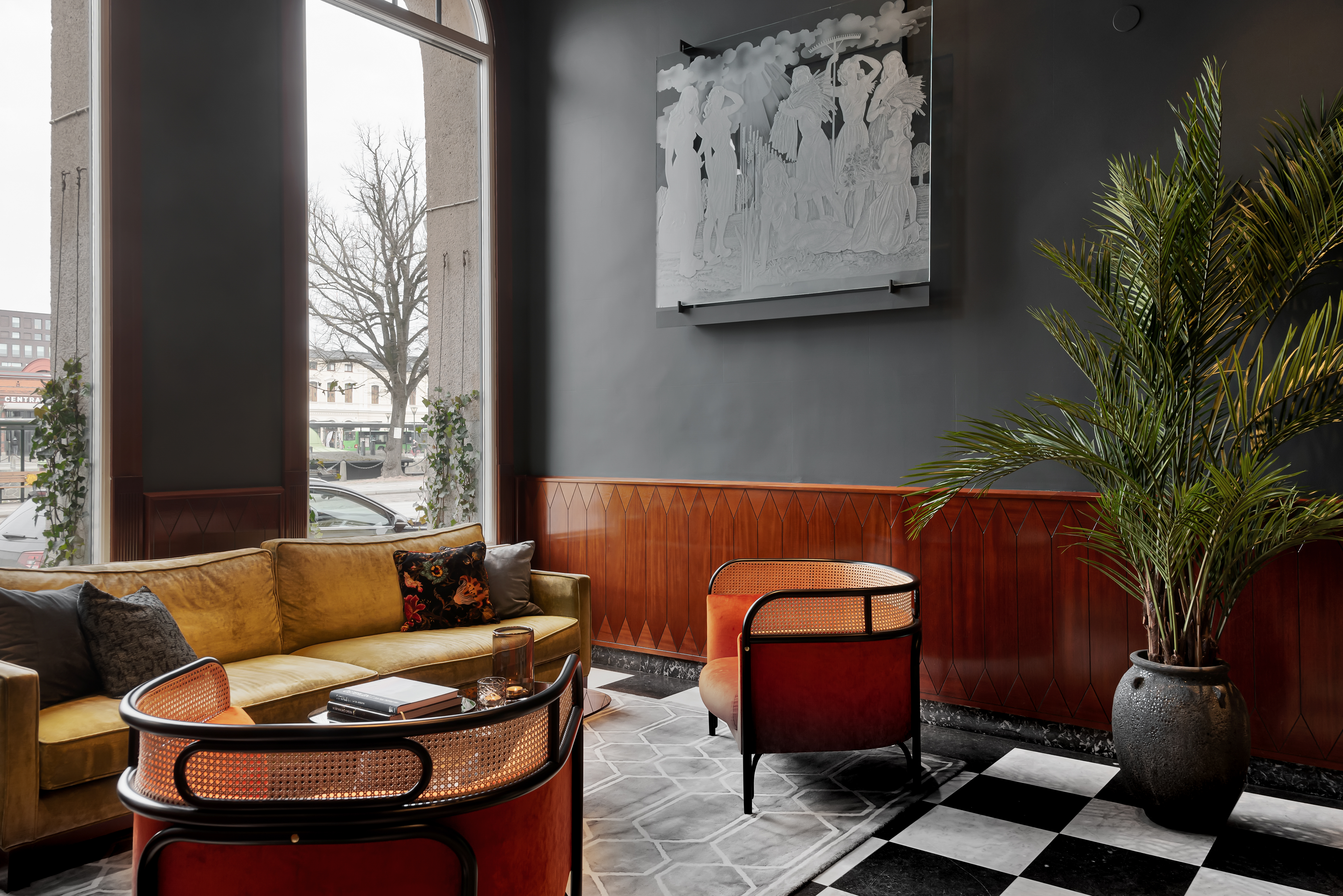 Hotel lobby with lounge group, potted plants and paintings