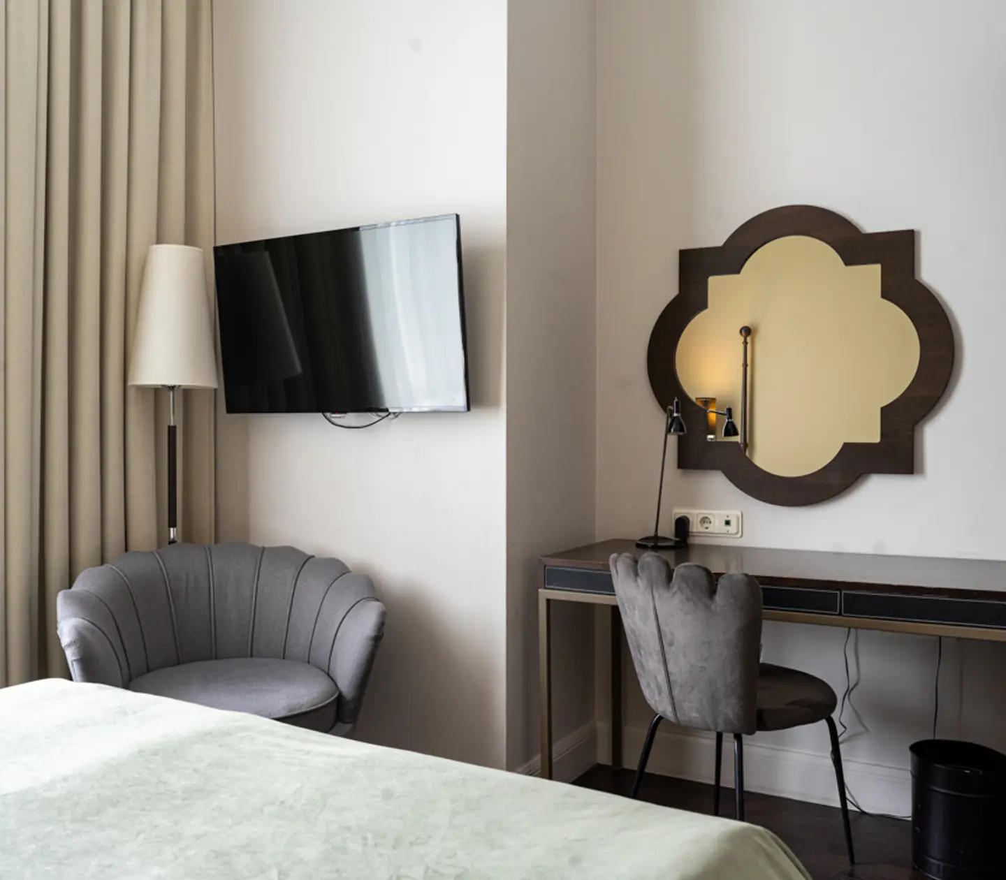 Ljust hotellrum med skrivbord, spegel och sänglampa