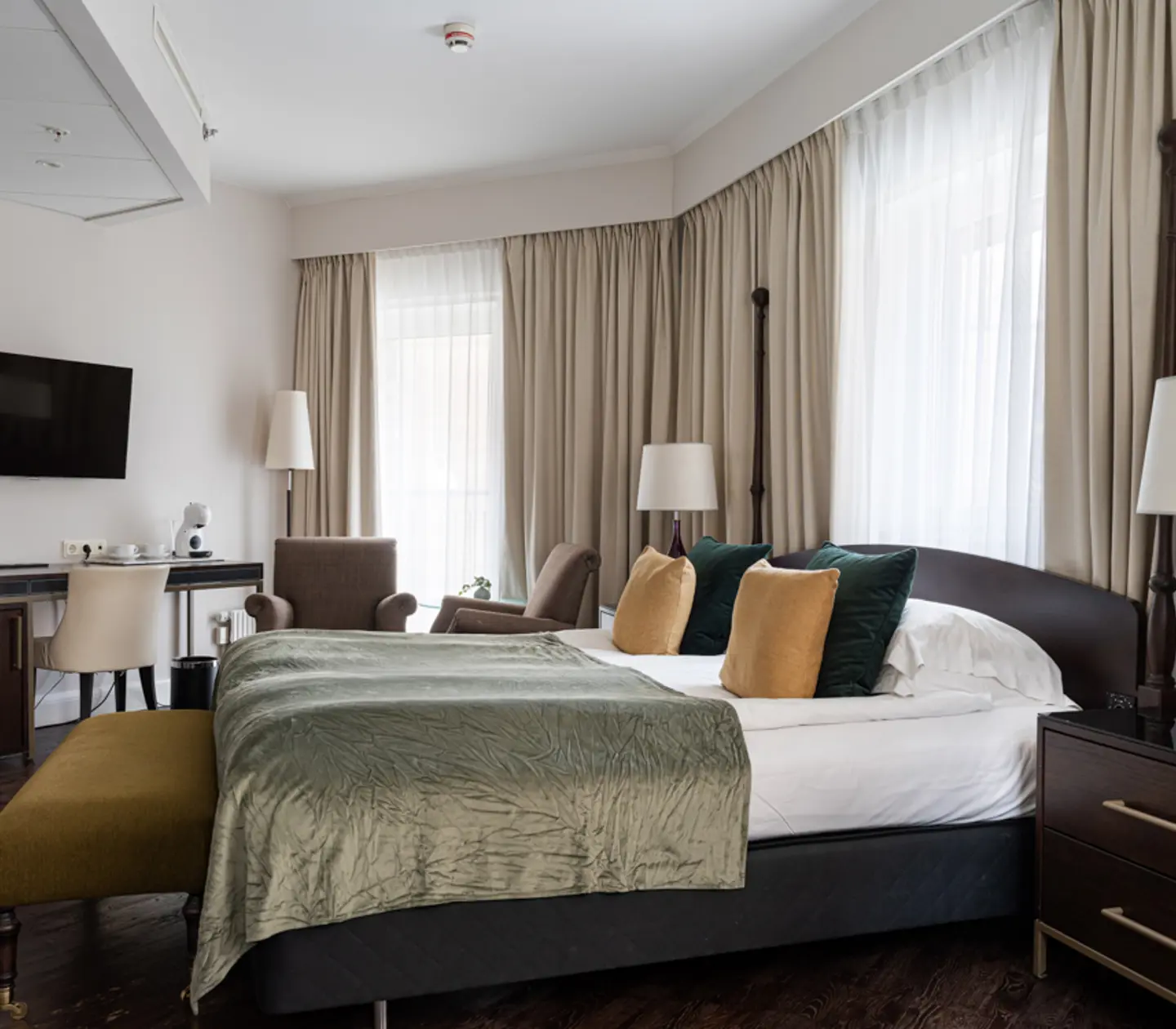 Mysigt hotellrum med säng, spegel och skrivbord