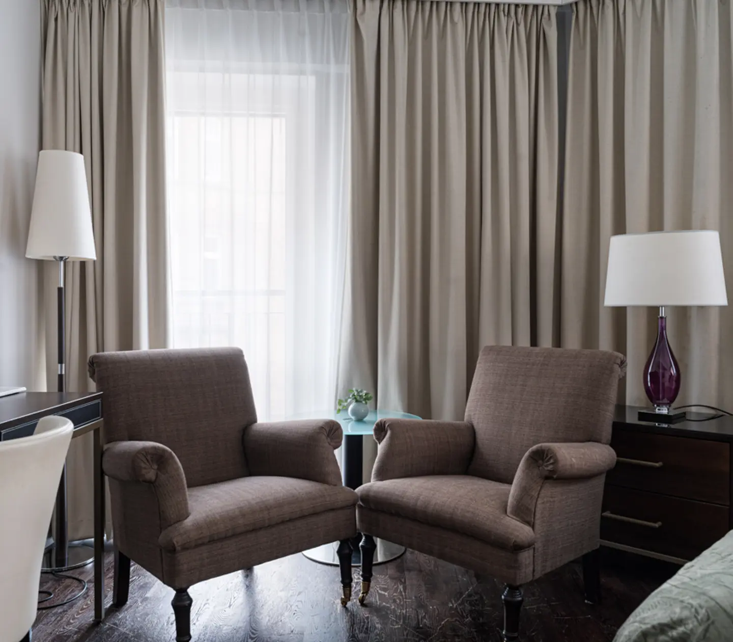 Mysigt hotellrum med säng, gardiner och skrivbord