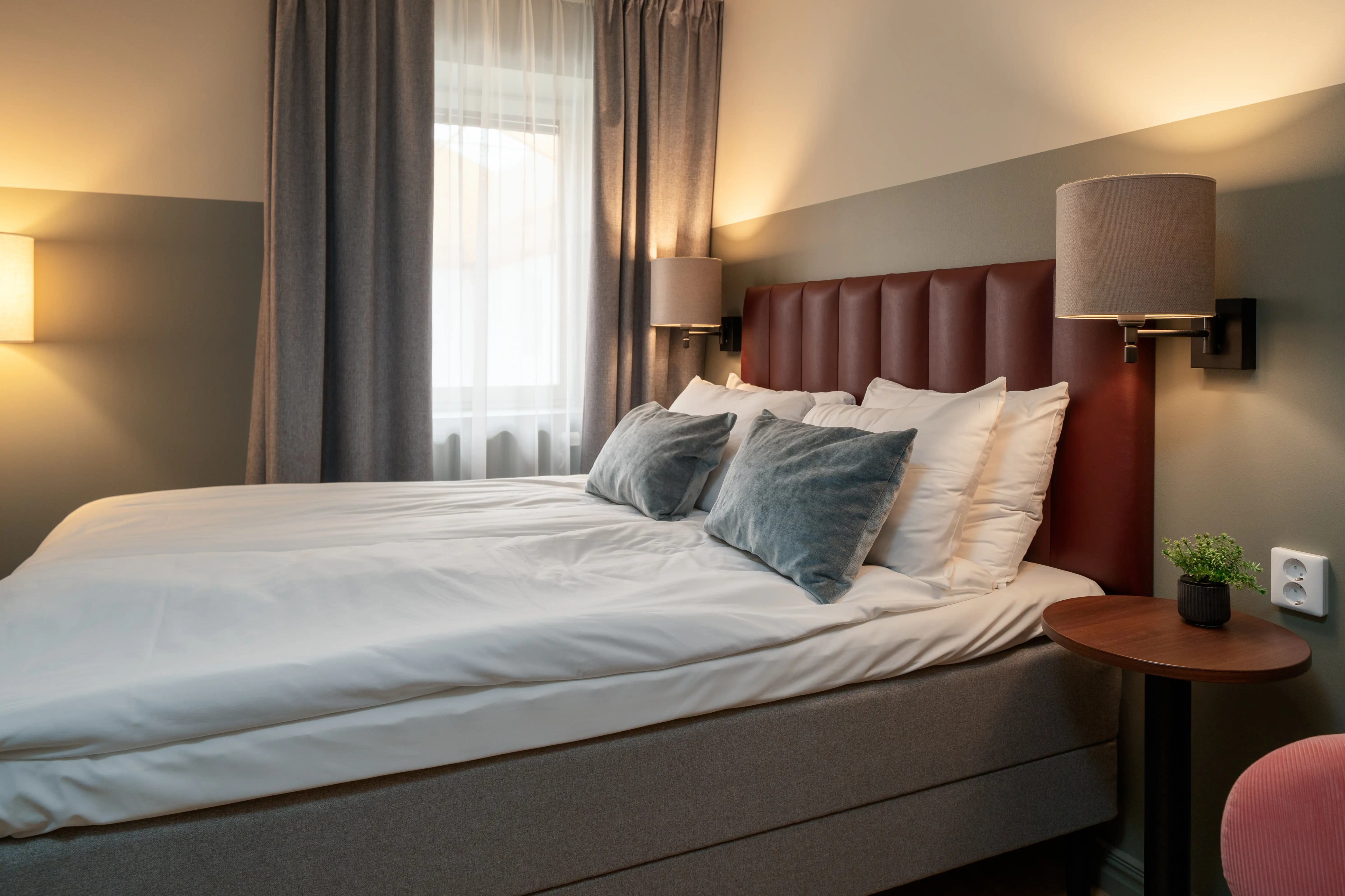 Comfortable hotel room with double bed, bedside lamps and window
