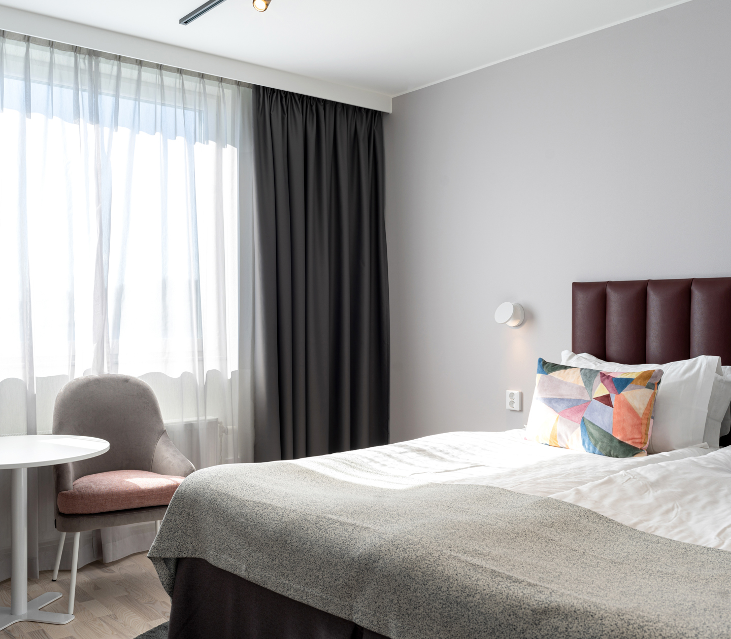 Hotel room with double bed and armchairs