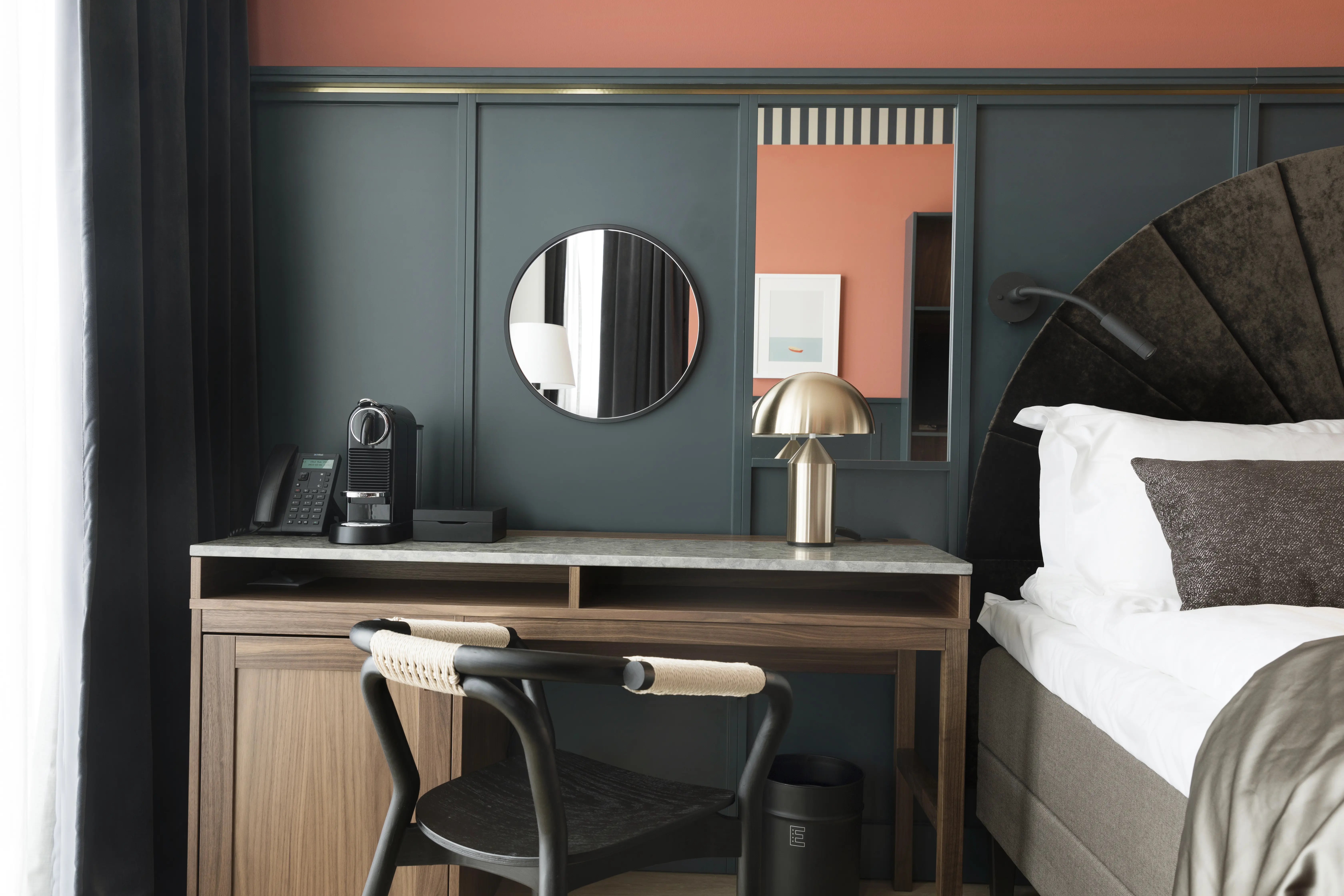 Mysigt hotellrum med säng, skrivbord, blå och röd vägg