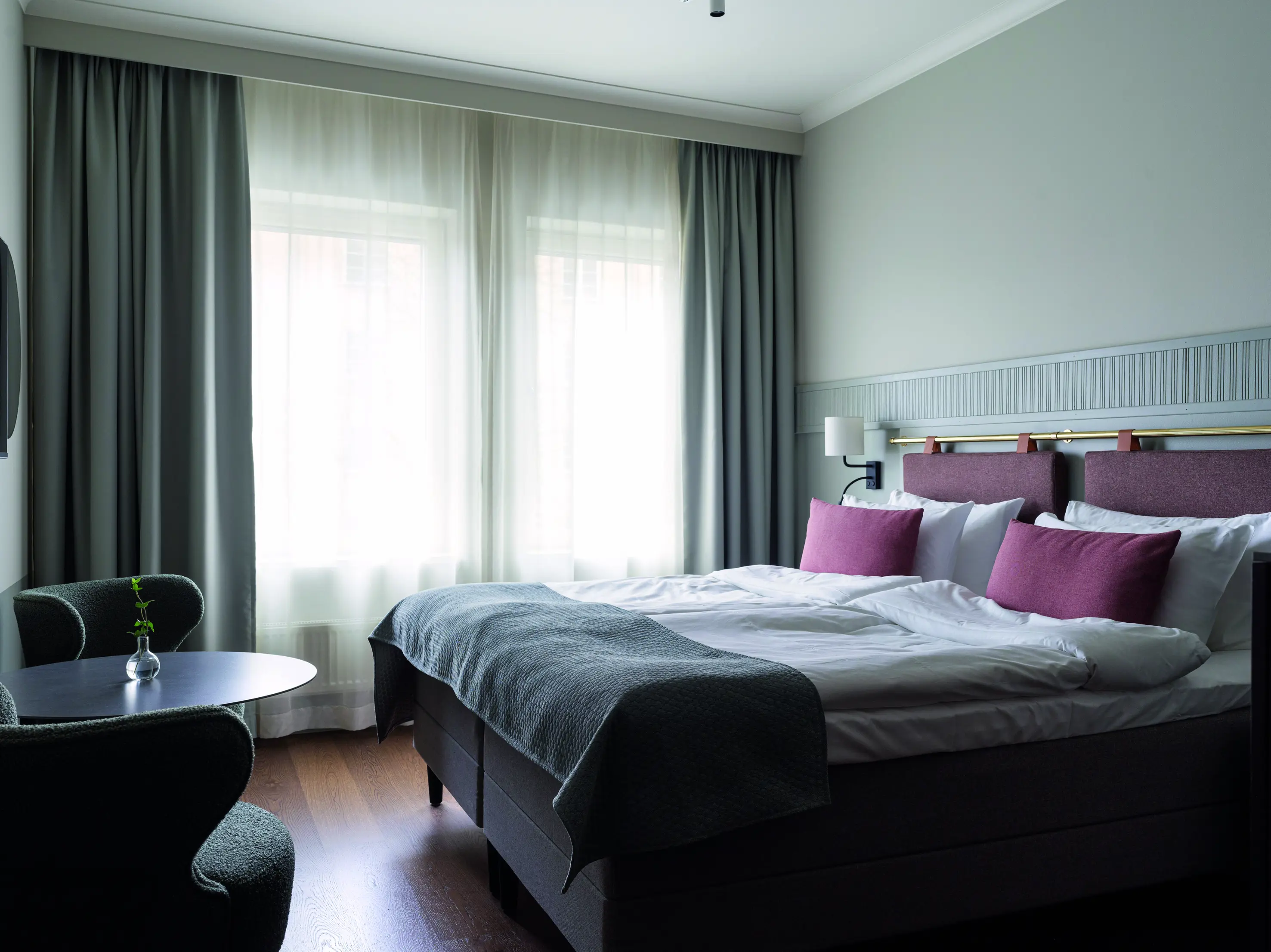 A room with a double bed and pink pillows
