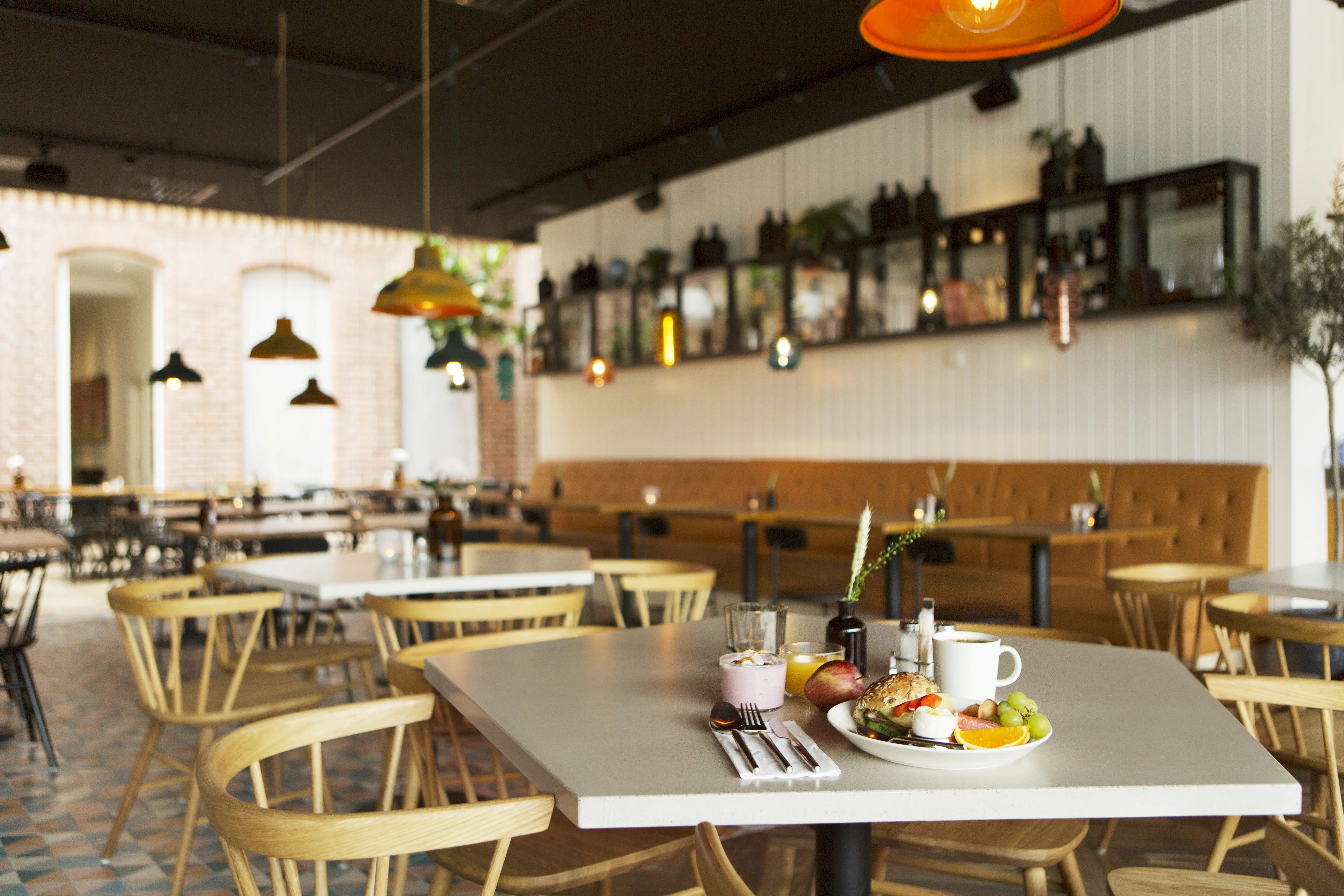 Restaurant environment with breakfast served on tables and dining groups in the background