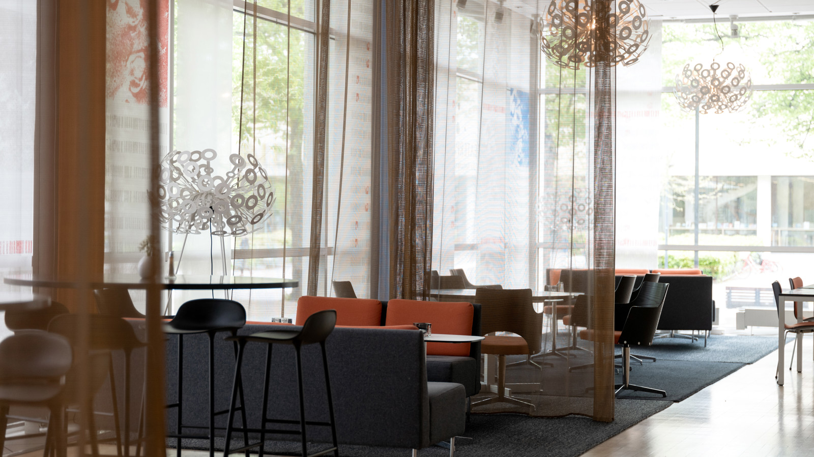 Hotellobby med loungestolar och stora fönster