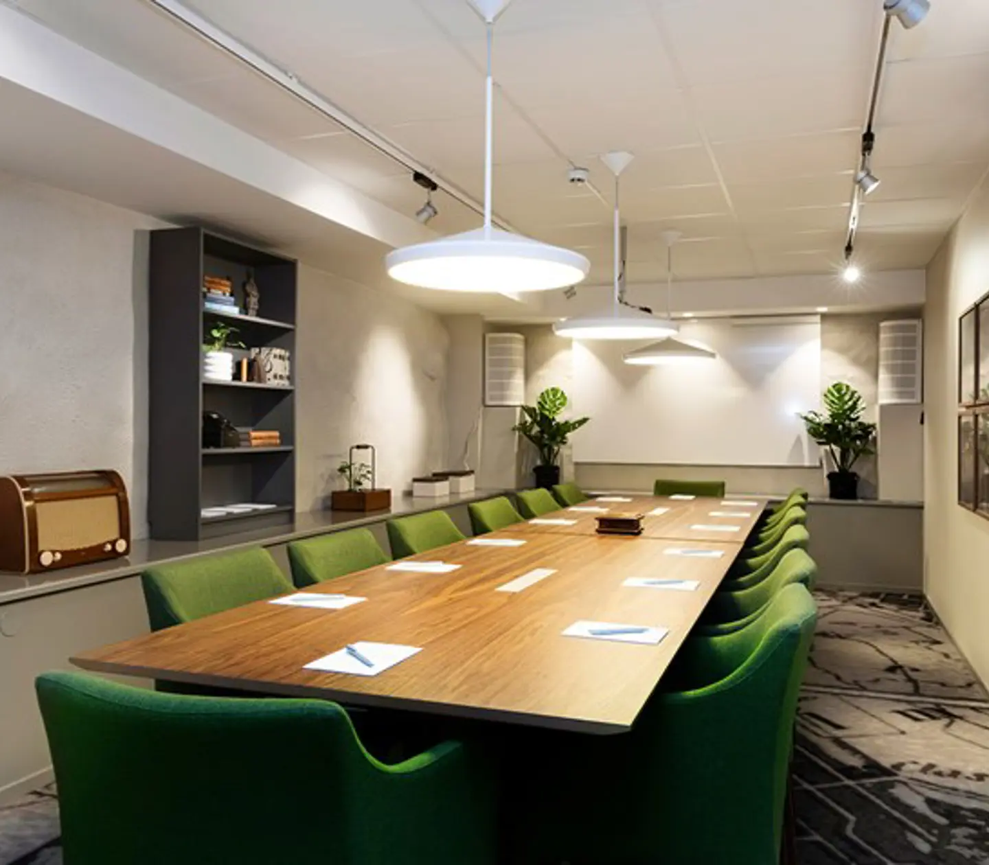 Conference room with board seating, dark brown table and green chairs