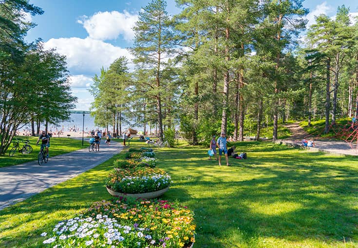 En grönskande park som leder ner till en sandstrand